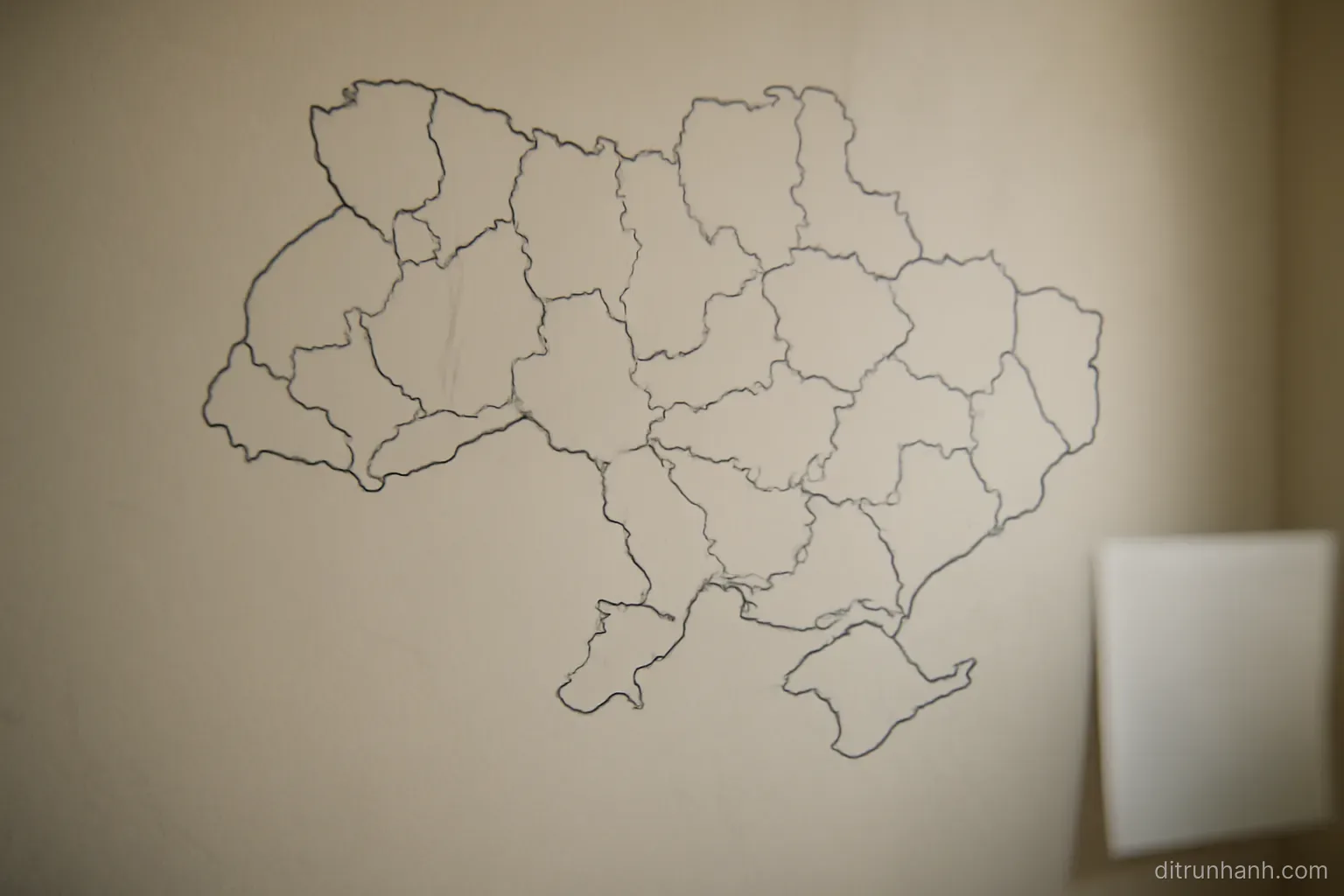 a plain regional map on a wall with several areas outlined in marker and no place names legible